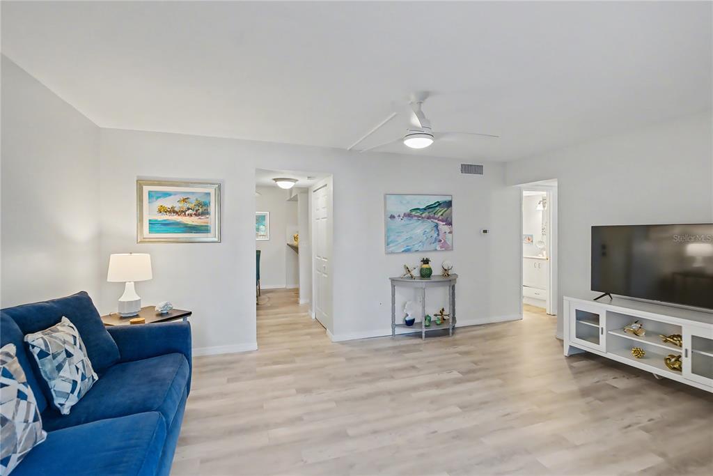 6157 Midnight Pass Road, Unit E23 Sarasota, FL 34242 - Photo 10 of 49 a living room with furniture and a flat screen tv
