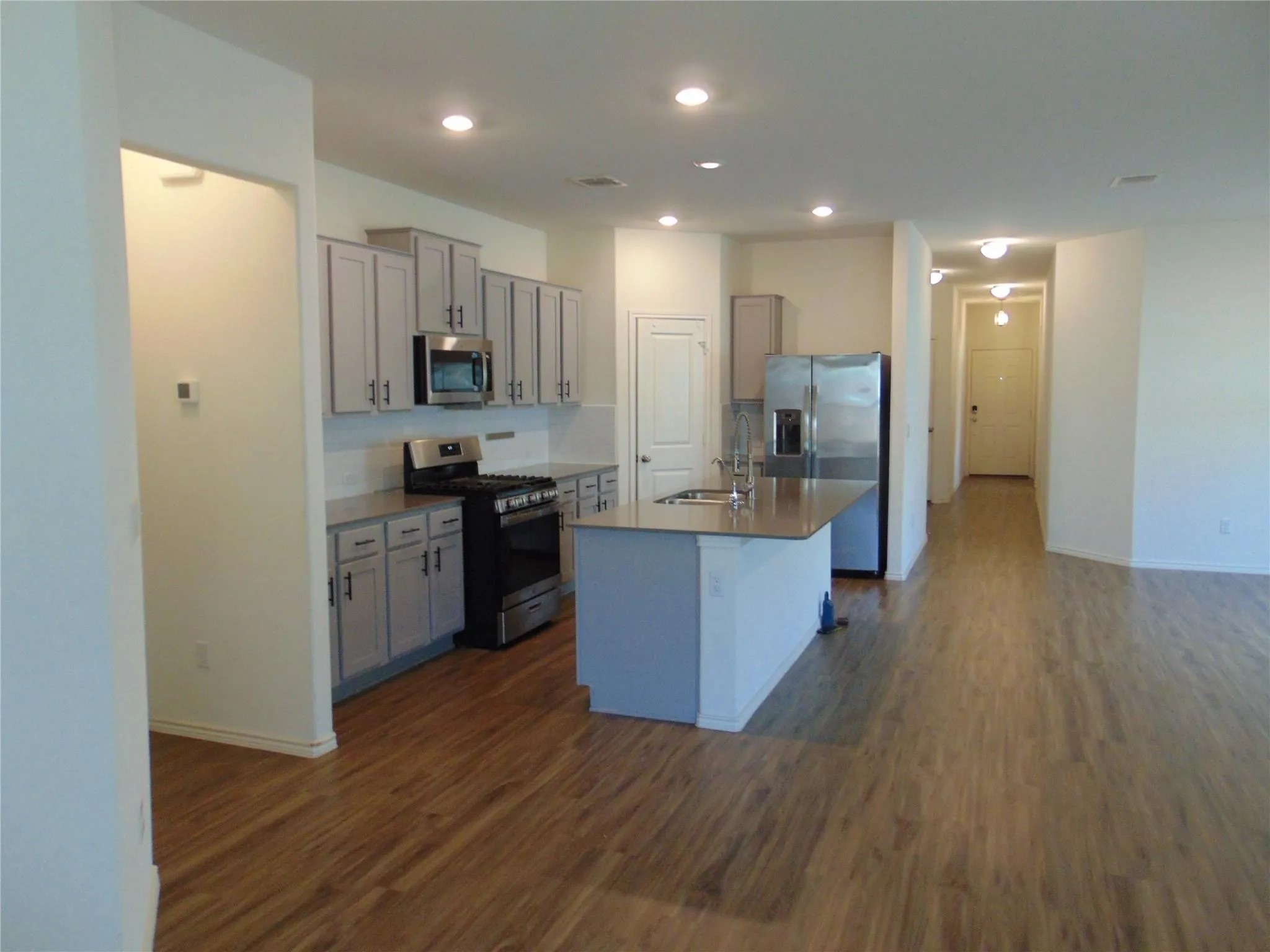181 Crystal River Road Kyle, TX 78640 - Photo 2 of 9 a large kitchen with stainless steel appliances kitchen island a large counter top and a wooden floors