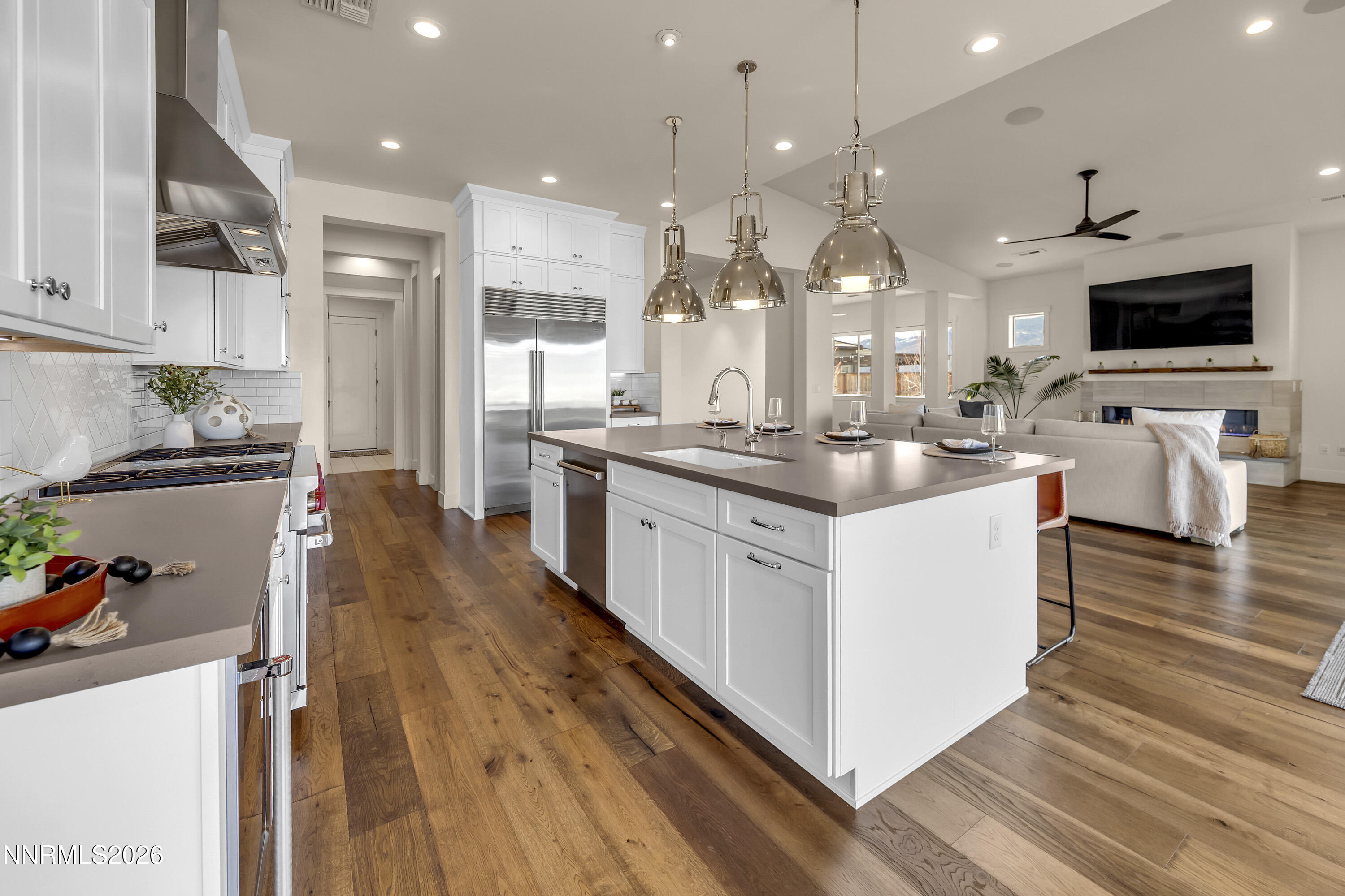9219 Wild Skies Court Reno, NV 89523 - Photo 14 of 38 a large kitchen with stainless steel appliances kitchen island granite countertop a large center island and a wooden floor