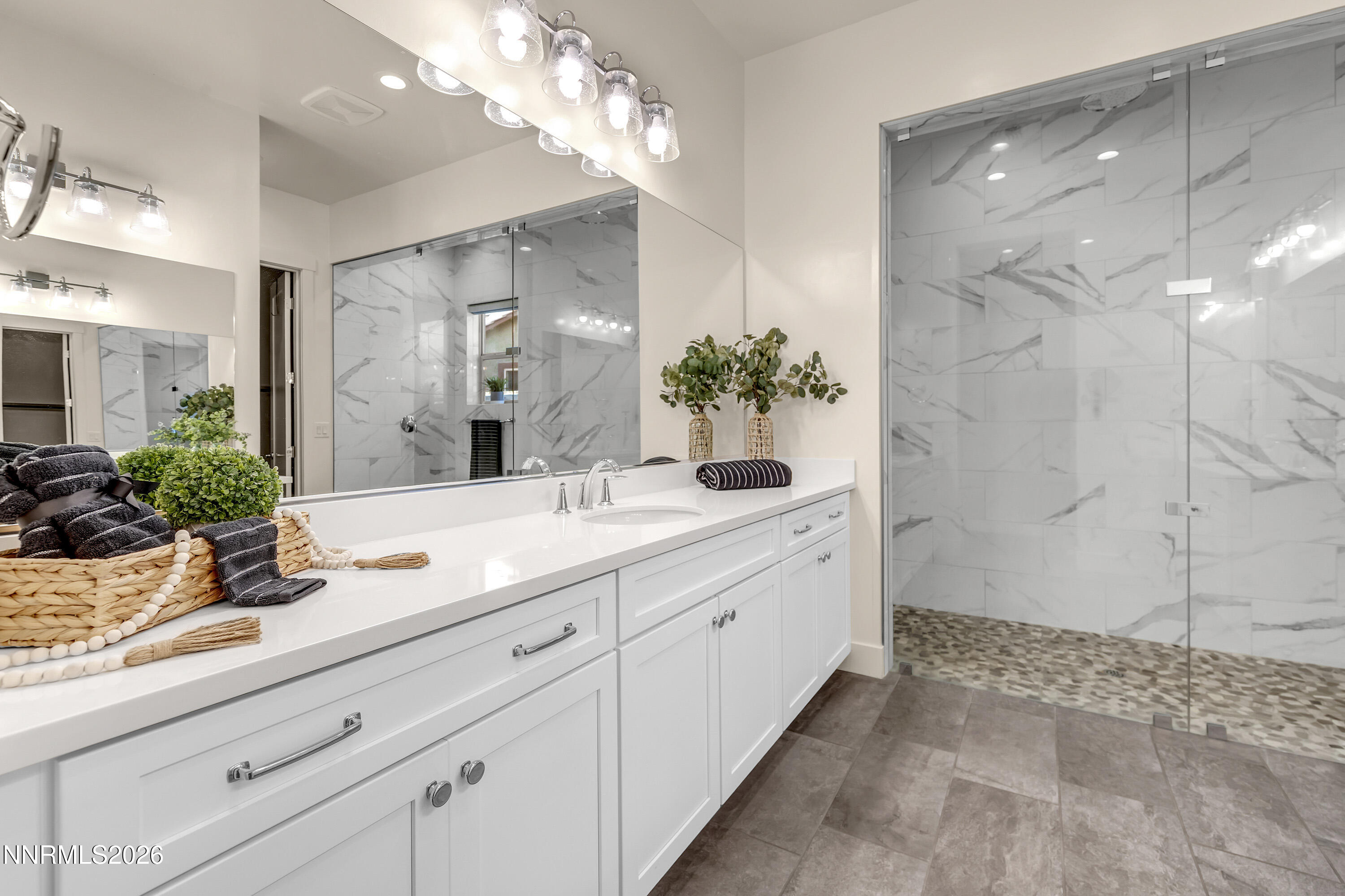 9219 Wild Skies Court Reno, NV 89523 - Photo 26 of 38 a bathroom with a granite countertop sink a mirror and a shower