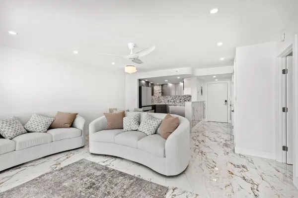 a living room with furniture and kitchen view