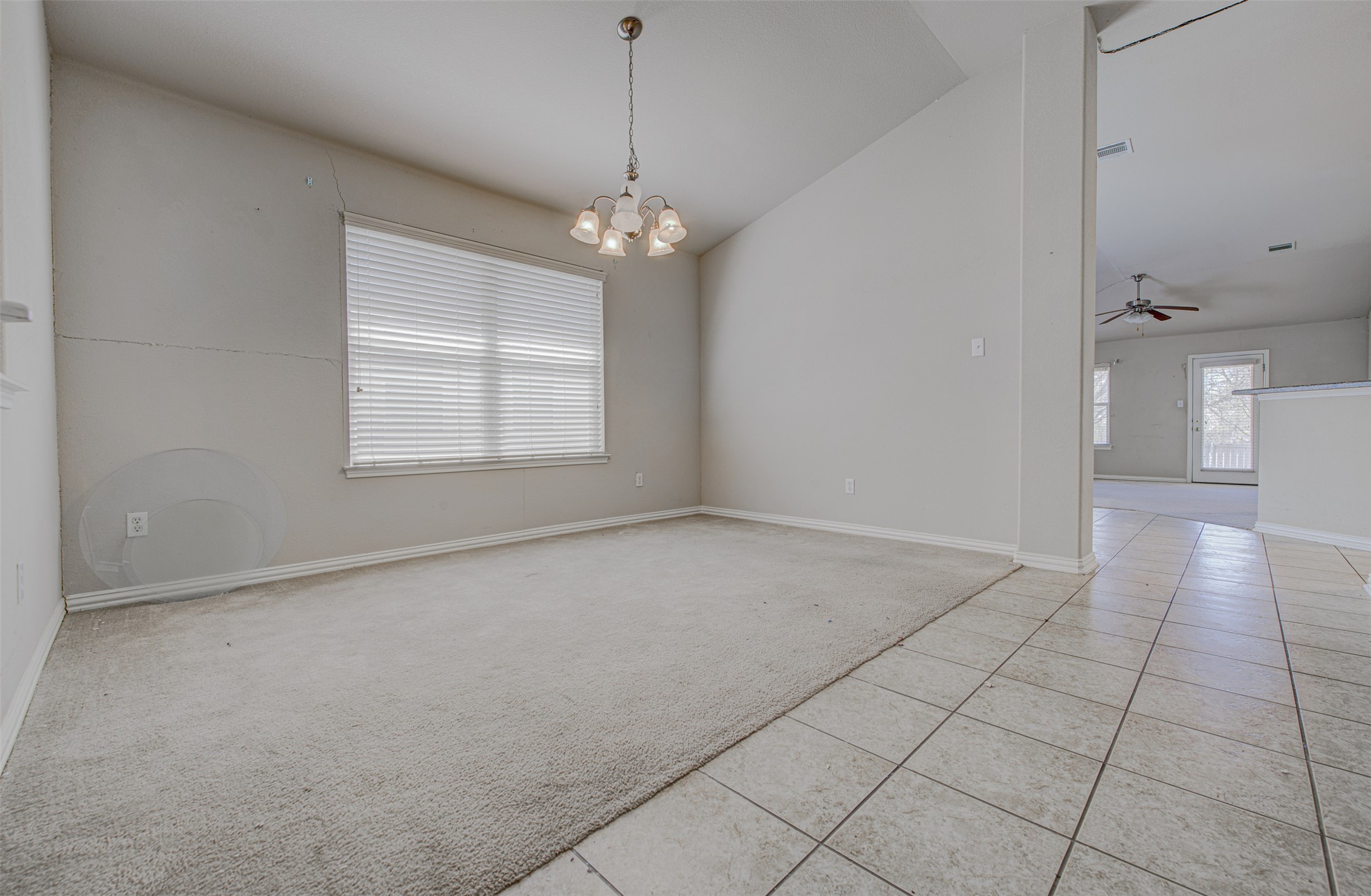 2090 Intrepid Drive Buda, TX 78610 - Photo 5 of 24 Spare room with vaulted ceiling, suspended lighting, light colored carpet, light tile patterned floors, and ceiling fan