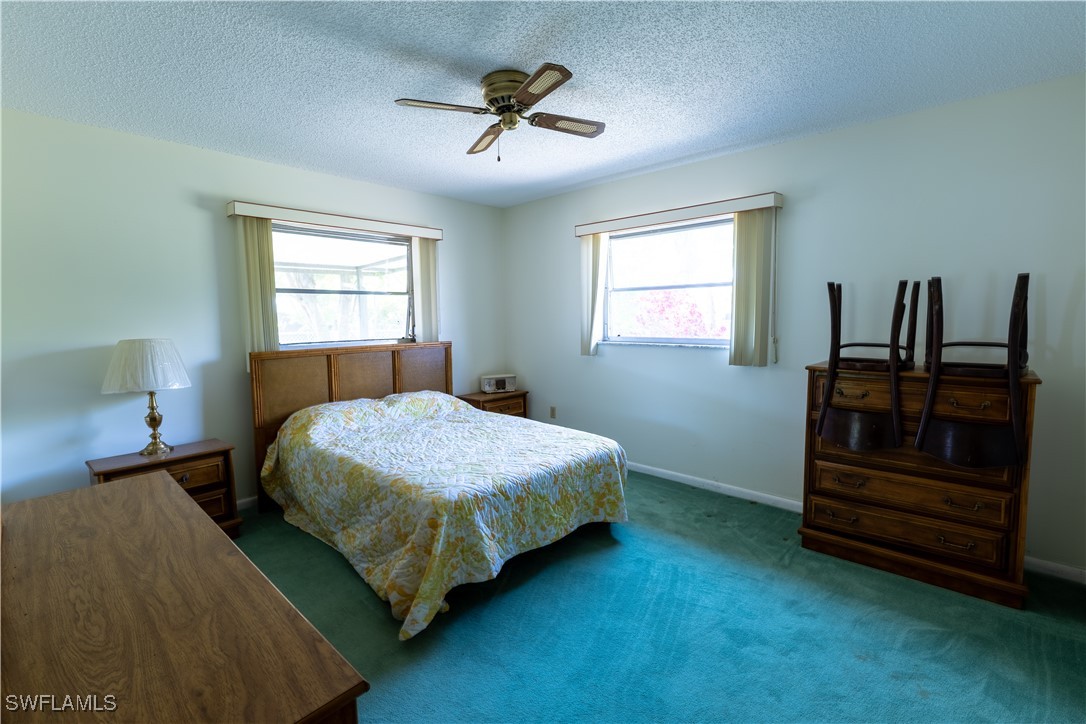 4646 Palm Tree Boulevard Cape Coral, FL 33904 - Photo 13 of 36 a bedroom with a bed and a ceiling fan