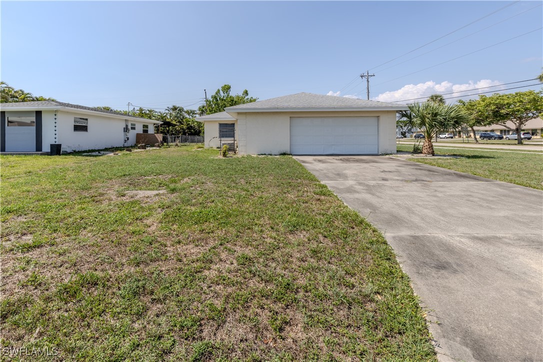 4646 Palm Tree Boulevard Cape Coral, FL 33904 - Photo 3 of 36 a front view of a house with a yard and a garage