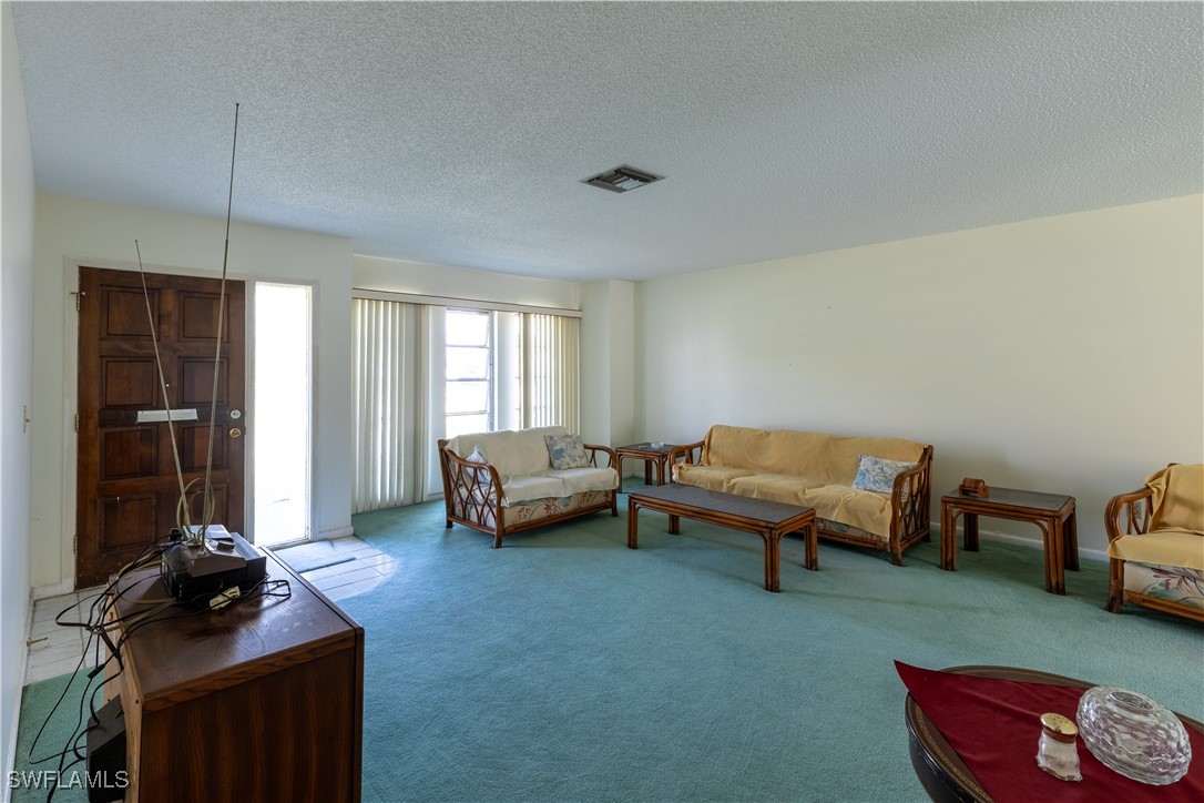 4646 Palm Tree Boulevard Cape Coral, FL 33904 - Photo 7 of 36 a living room with furniture a window and a flat screen tv