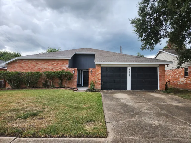 a front view of a house with a garden and yard