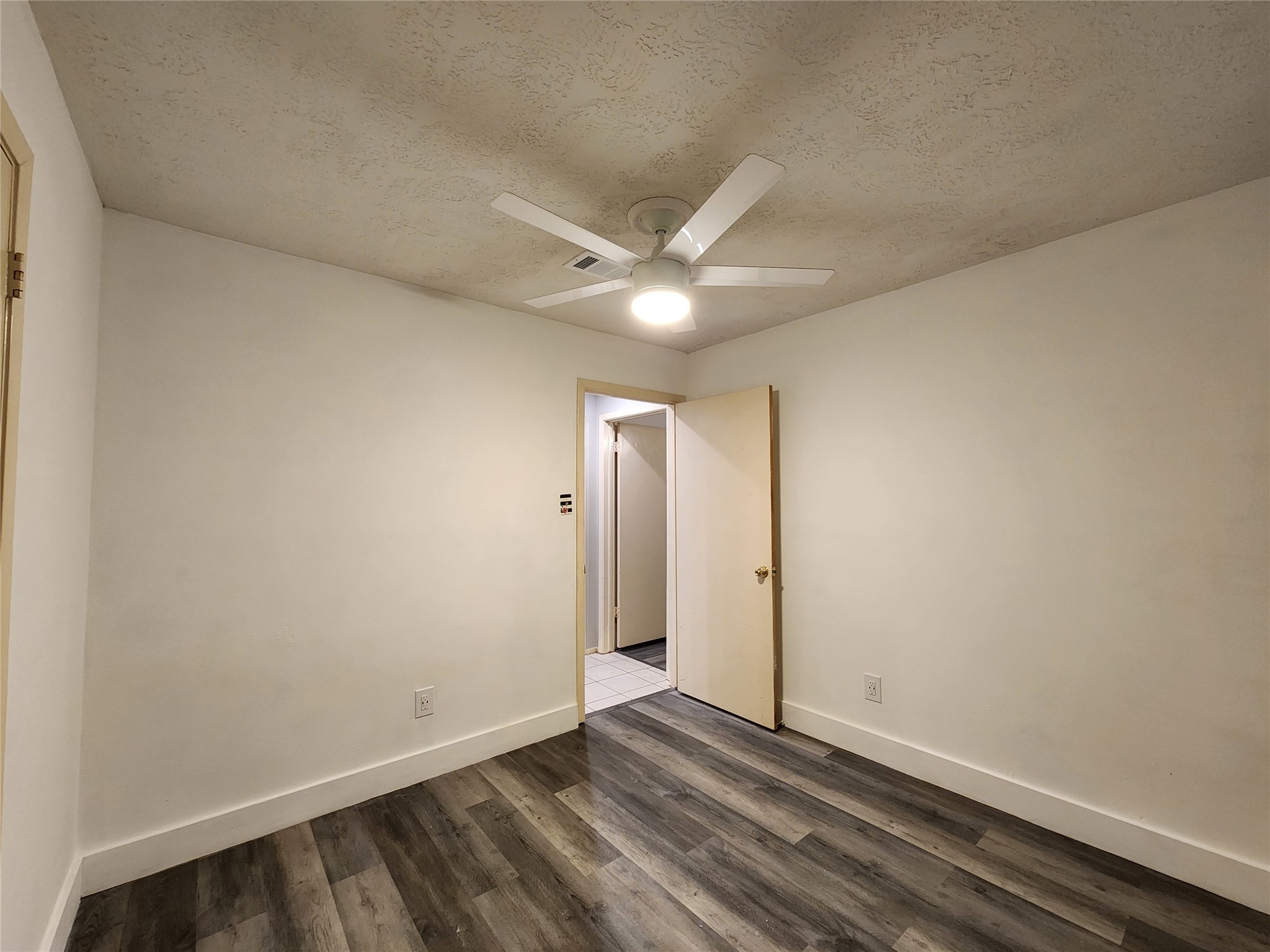 8327 Bird Run Drive Houston, TX 77489 - Photo 9 of 18 an empty room with wooden floor and a ceiling fan