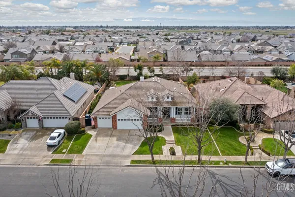 an aerial view of a house with a yard and lake view