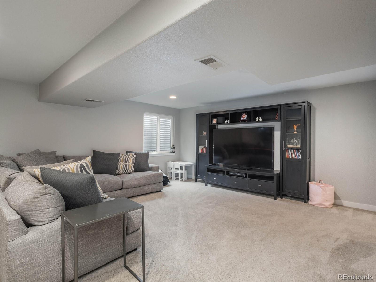 1005 Northridge Road Highlands Ranch, CO 80126 - Photo 19 of 28 a living room with furniture and a flat screen tv