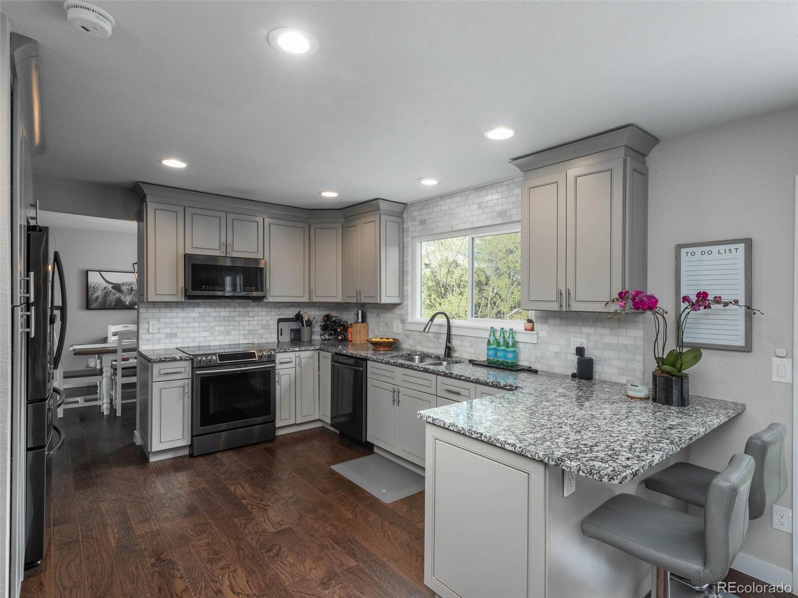 1005 Northridge Road Highlands Ranch, CO 80126 - Photo 6 of 28 a kitchen with granite countertop kitchen island stainless steel appliances a sink stove and refrigerator