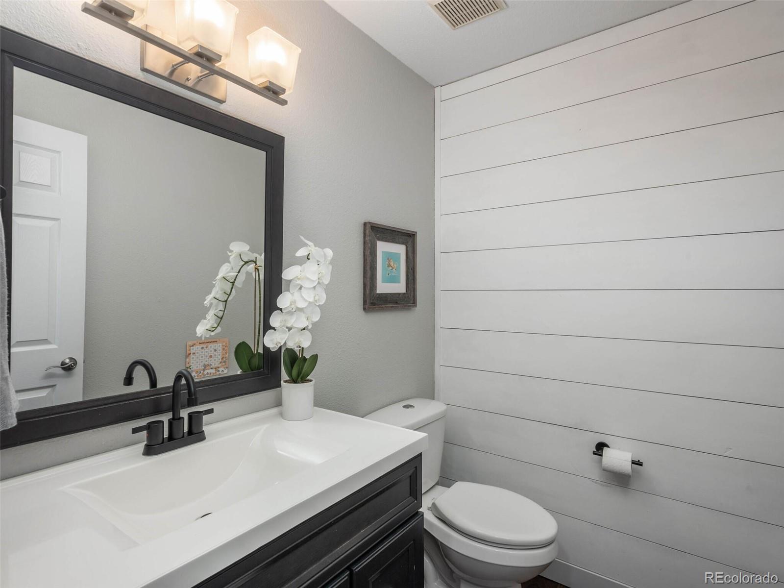 1005 Northridge Road Highlands Ranch, CO 80126 - Photo 9 of 28 a bathroom with a sink a toilet and mirror