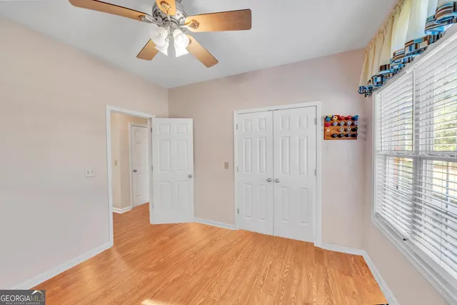 a view of empty room with window and ceiling fan