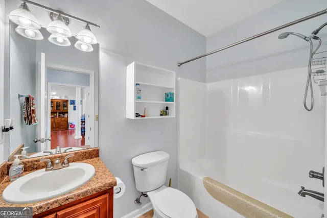 a bathroom with a sink toilet a mirror and shower