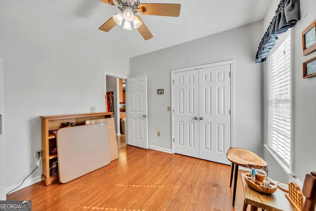 a view of a room with wooden floor and ceiling fan