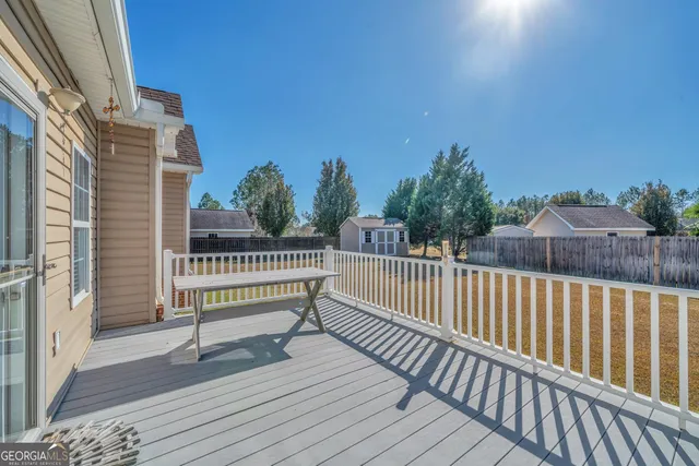 a view of a balcony with wooden floor and fence
