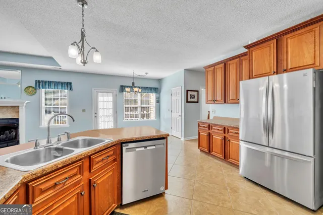 a kitchen with stainless steel appliances granite countertop a sink refrigerator and cabinets