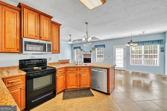 a kitchen with stainless steel appliances granite countertop a stove a sink and a microwave