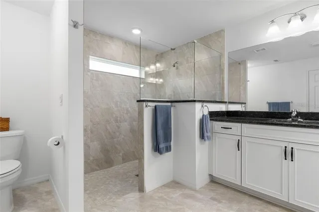 a bedroom with a large bed and a flat tv screen on dresser