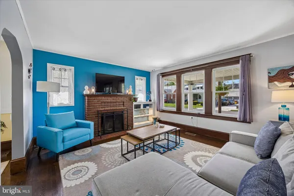 a living room with furniture a fireplace and a large window