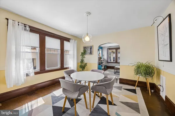 a dining room with furniture a chandelier and wooden floor