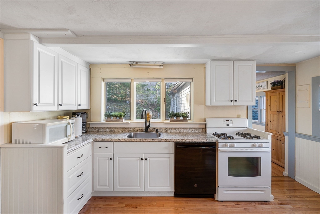 11 W Road Sandwich, MA 02644 - Photo 18 of 42 a kitchen with granite countertop white cabinets and white appliances