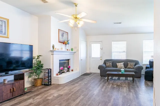 a living room with furniture a fireplace and a flat screen tv