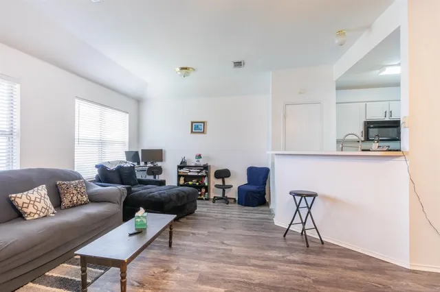 a living room with furniture and a wooden floor