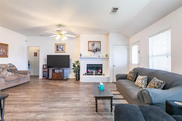 a living room with furniture a fireplace and a flat screen tv