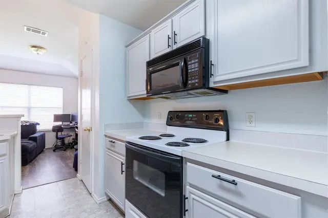 a kitchen with stainless steel appliances a stove microwave and refrigerator