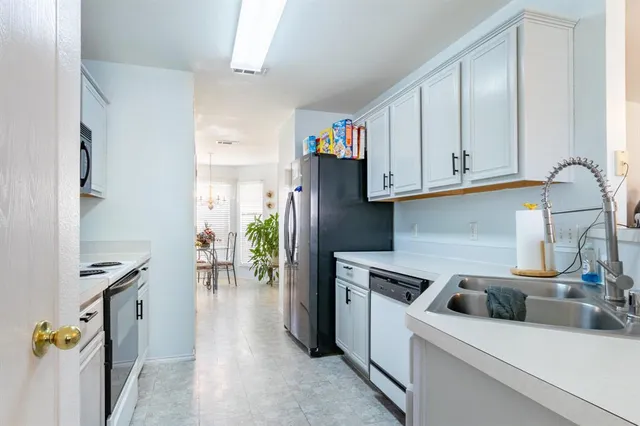 a kitchen with stainless steel appliances granite countertop a refrigerator and a sink