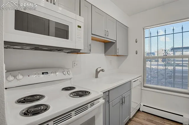 a kitchen with kitchen island a stove a sink and white cabinets