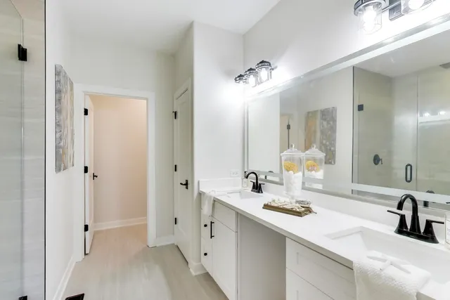 a bathroom with a double vanity sink mirror and shower