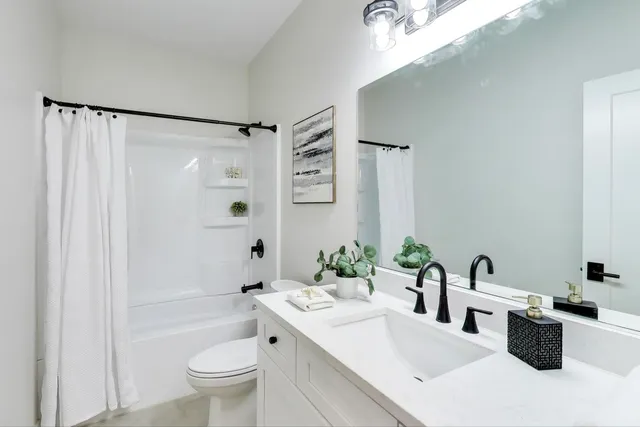 a bathroom with a double vanity sink toilet and shower