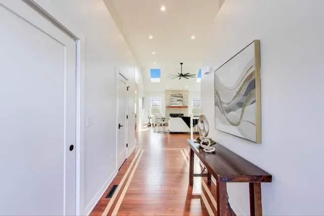 a view of a hallway with wooden floor and staircase