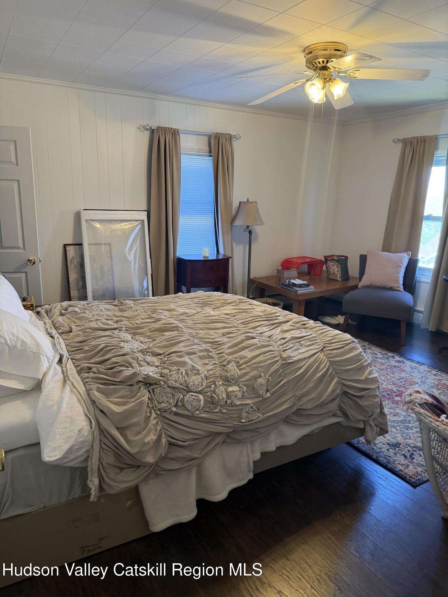 129 Main Street, Unit 3 Philmont, NY 12529 - Photo 6 of 8 a bedroom with a bed and dresser with mirror