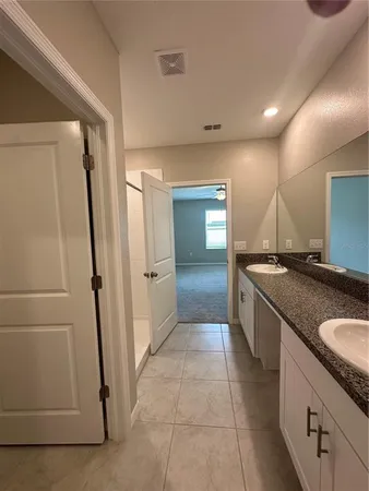 a bathroom with a granite countertop sink a toilet and mirror