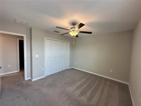 an empty room with a window and a fan