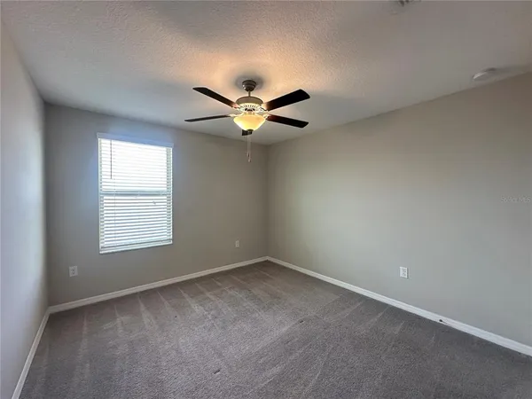 a view of an empty room and a ceiling fan