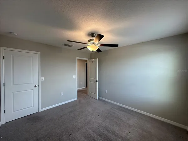 an empty room with closet and mirrors
