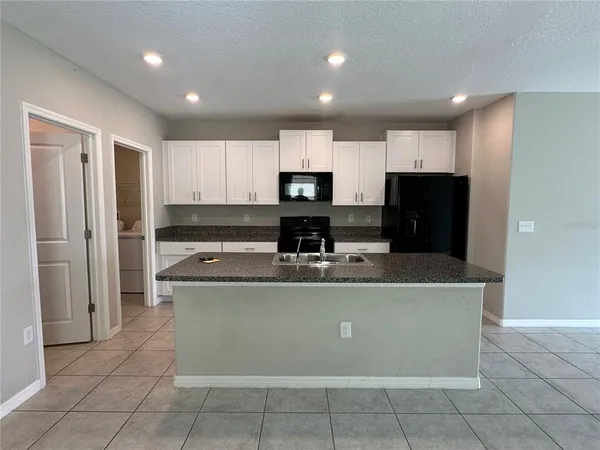 a view of kitchen with stainless steel appliances granite countertop a stove and a refrigerator