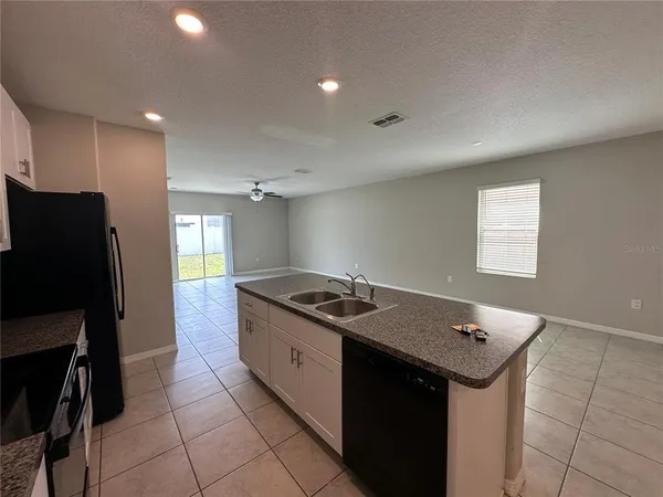 a kitchen that has a sink a stove and a refrigerator
