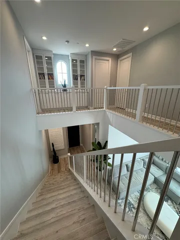 a view of a hallway with wooden floor and staircase