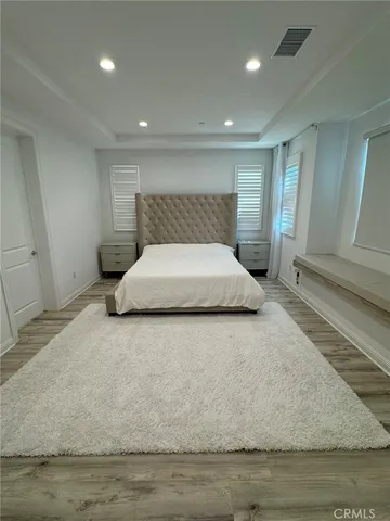 a large bedroom with a bed and a potted plant