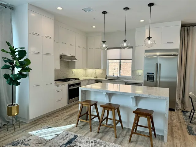 a kitchen with kitchen island a table and chairs in it