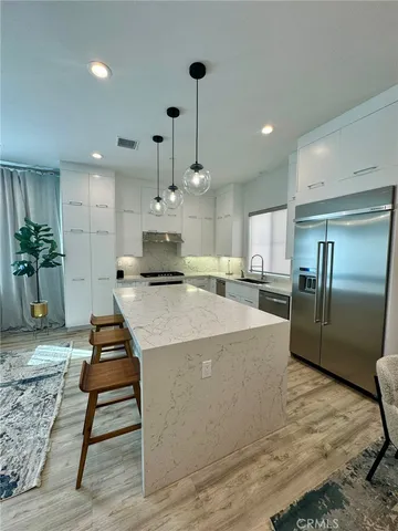 a large kitchen with kitchen island a counter top space appliances and cabinets