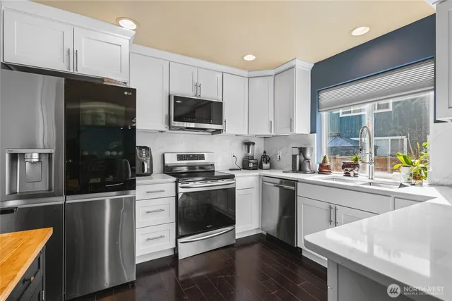 a kitchen with stainless steel appliances stove microwave and cabinets