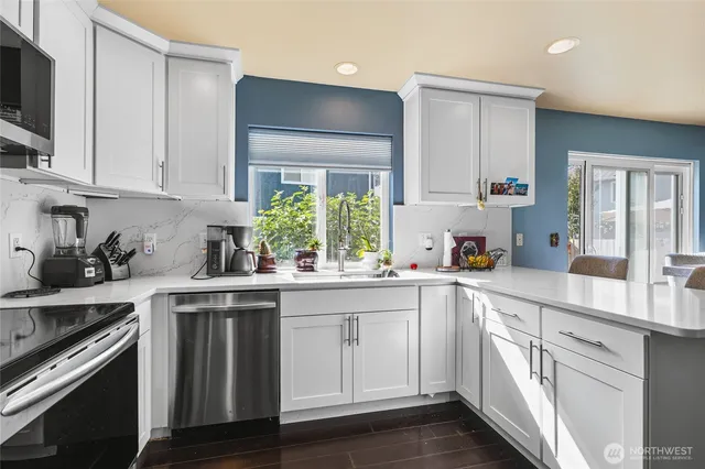 a kitchen with white cabinets and appliances