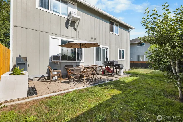 a view of a house with backyard and sitting area