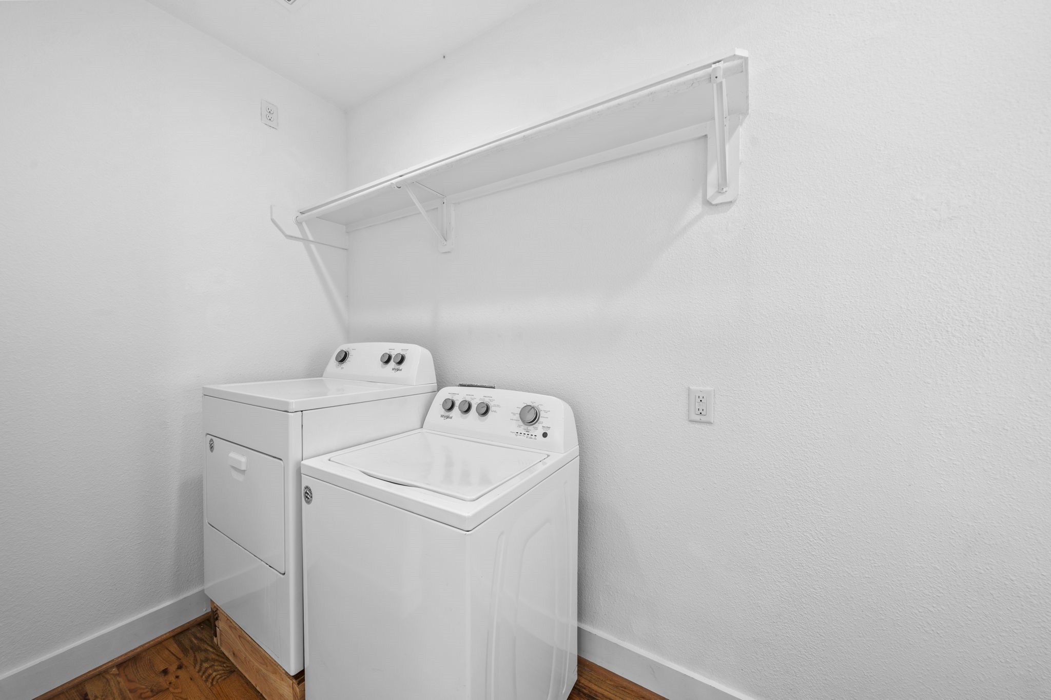 4734 Bell Street, Unit B Houston, TX 77023 - Photo 8 of 10 In-unit laundry area with washer and dryer placement, shelving above, and hard-surface flooring for everyday function.
