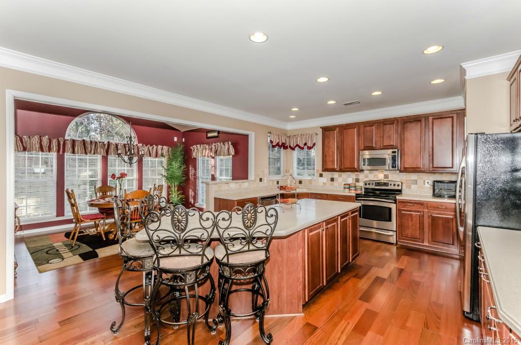 1982 Faison Avenue Fort Mill, SC 29708 - Photo 8 of 24 a kitchen with stainless steel appliances granite countertop a kitchen island hardwood floor sink stove dining table and chairs